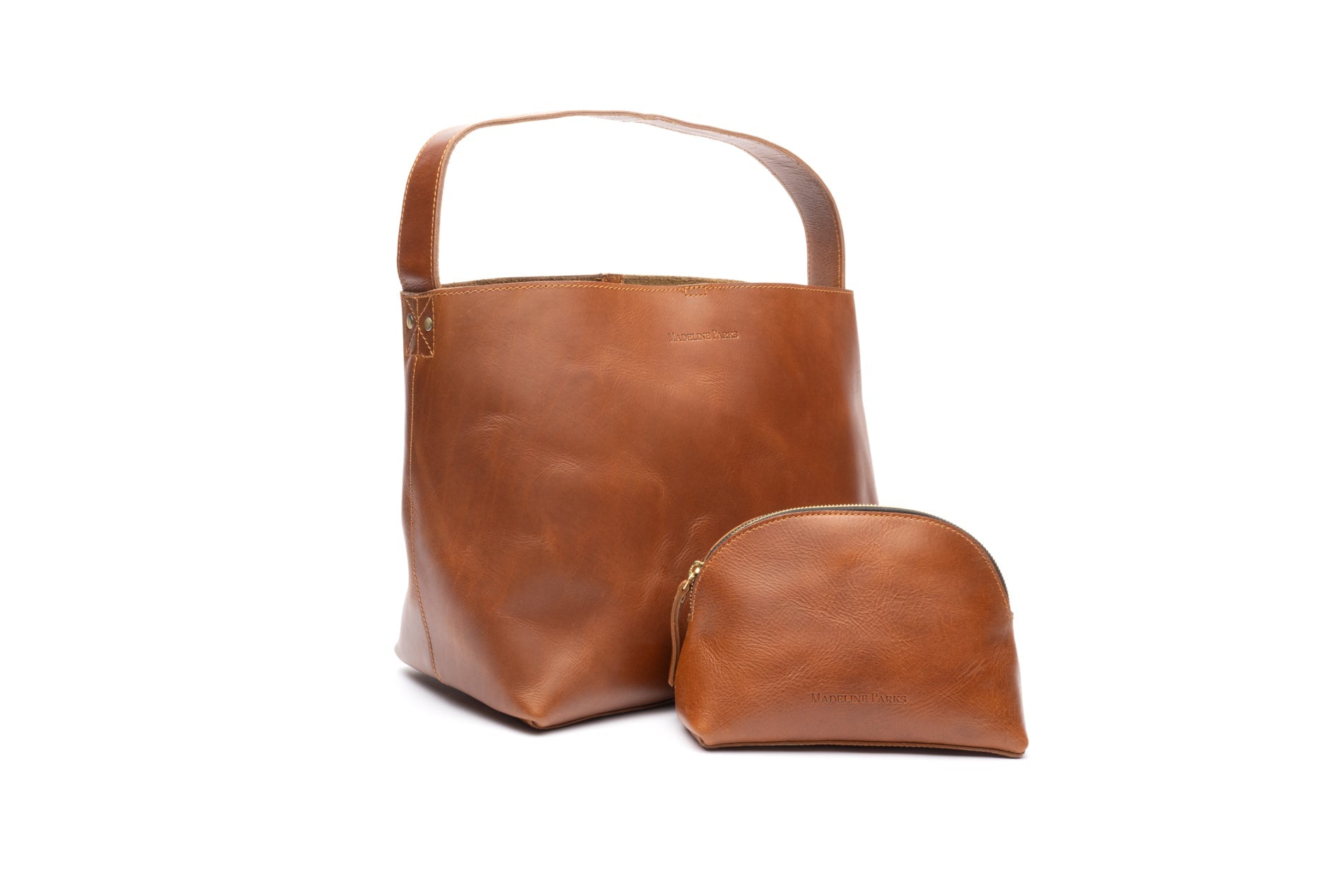 Two women each of one carrying a large leather bag and the other a small purse, both on hand embroidered fair trade purse straps in Madeline Parks Designs collection.