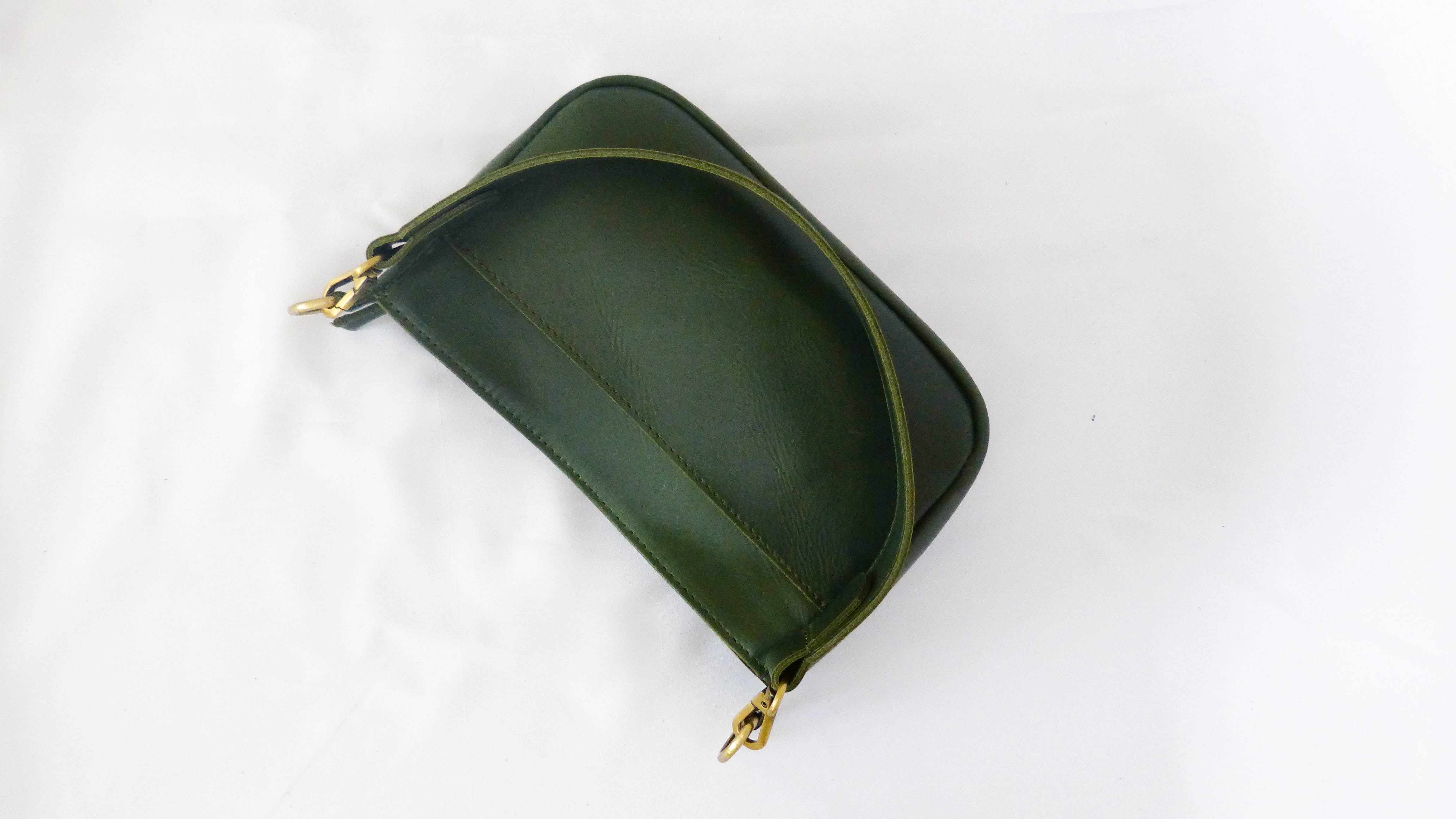 A green leather Jessica purse with a gold chain detail, featuring a zippered top and removable shoulder strap. Handmade by artisans in Ethiopia, perfect for everyday use.