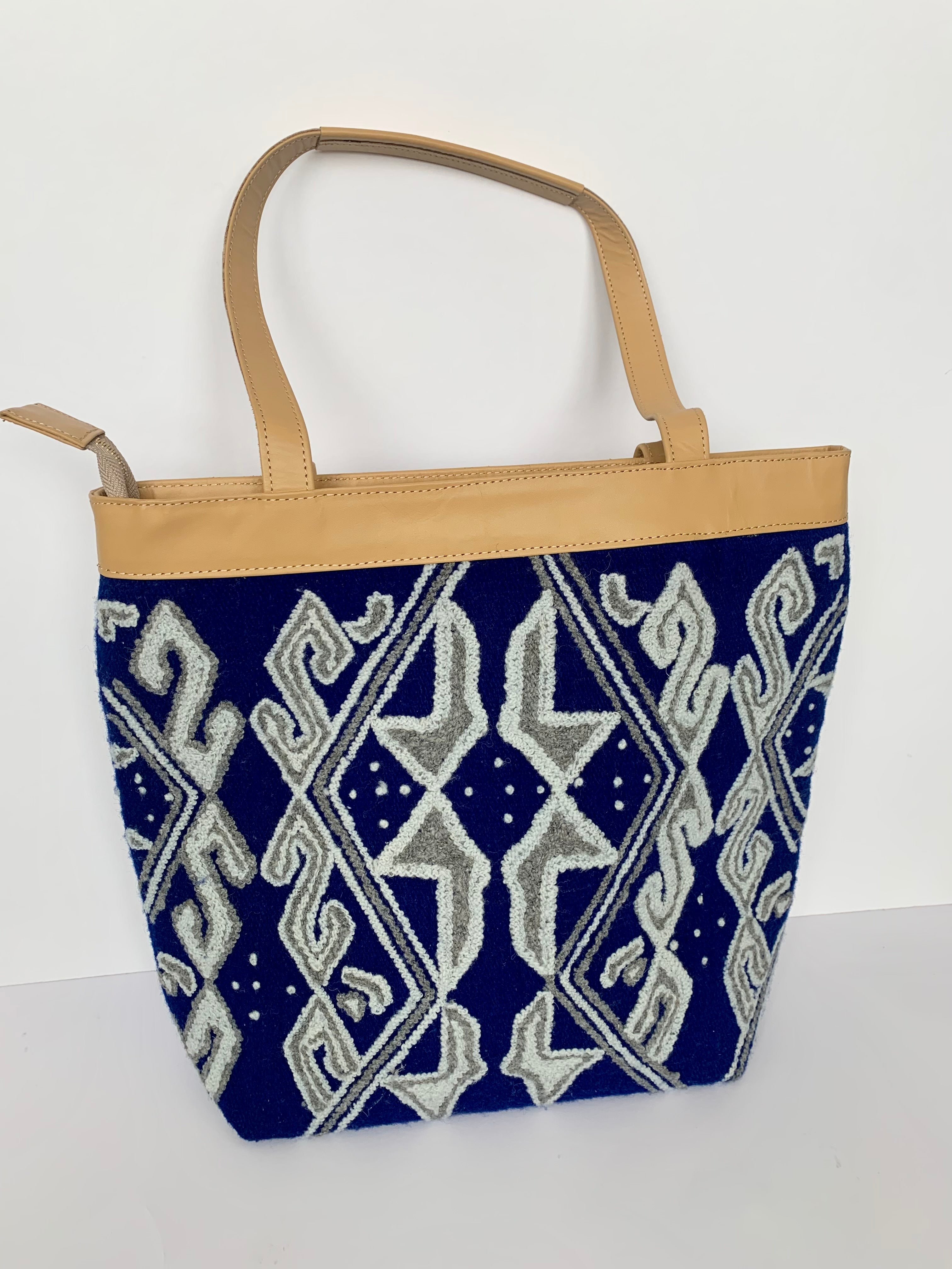 Navy and white embroidered tote bag with leather handles and zipper closure.
