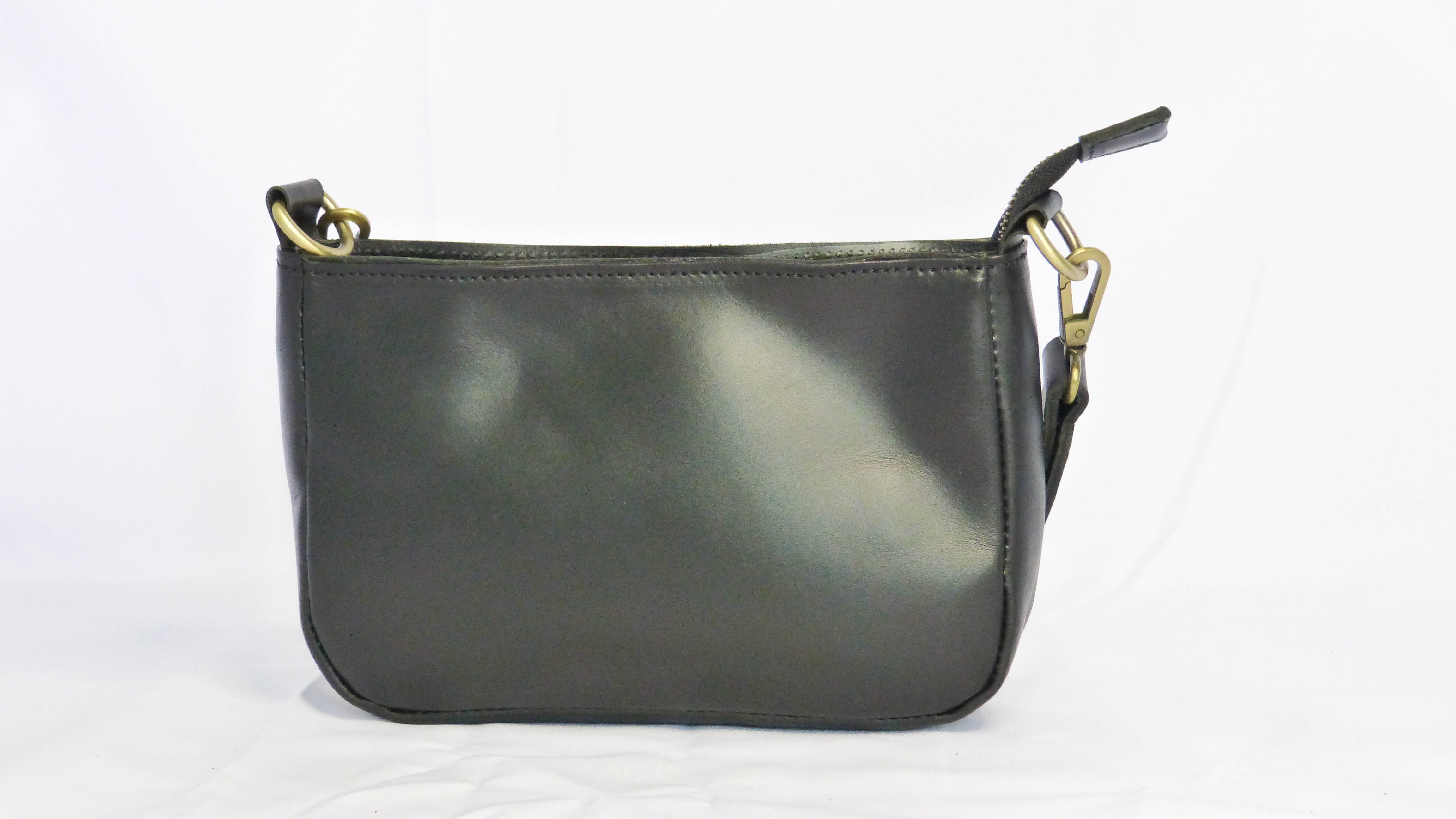 A black leather Jessica purse with removable shoulder strap. Zippered top, inside zipper pocket, and outside phone pocket. Handmade by Ethiopian artisans. Dimensions: 9 x 5.5 x 2.25.