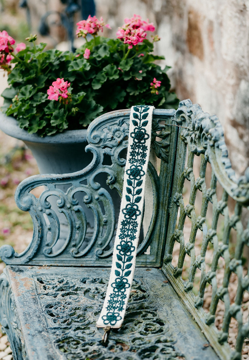 Jill Large Purse Strap displayed on a bench in an outdoor setting.