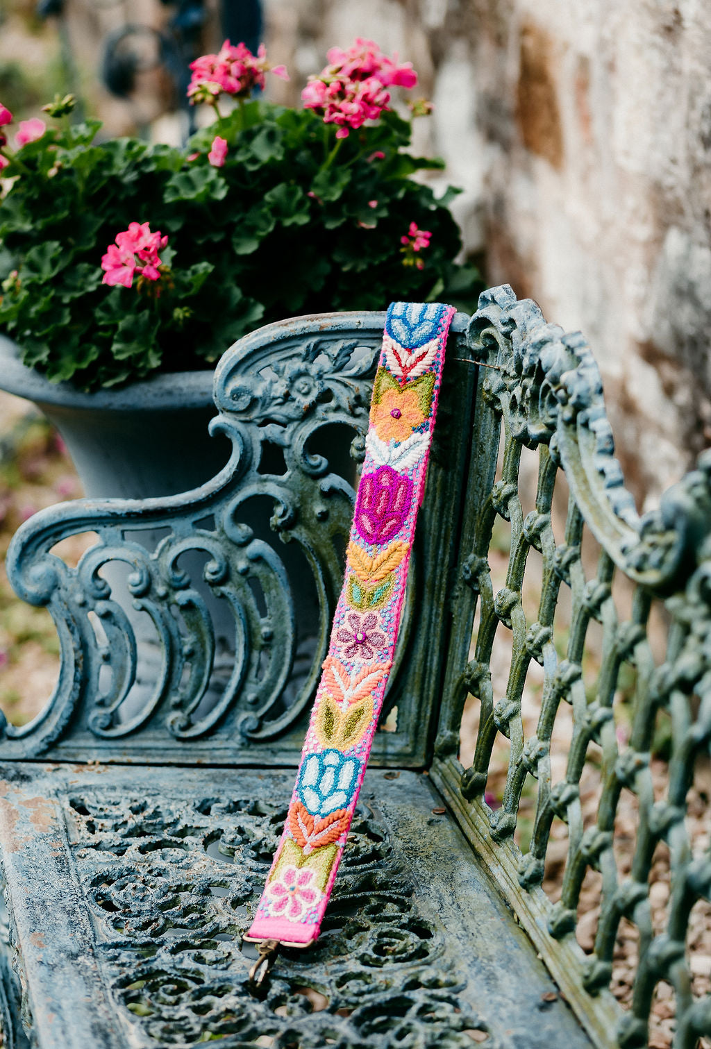 Hot Pink Large Strap displayed on a bench, adorned with colorful flowers and leaves.