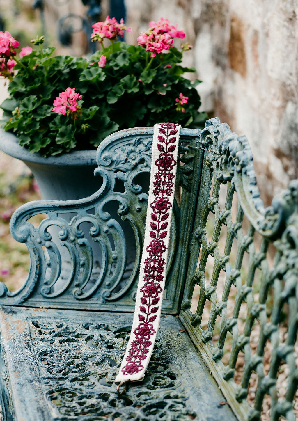 Wendi Large Purse Strap displayed on a bench in an outdoor setting.