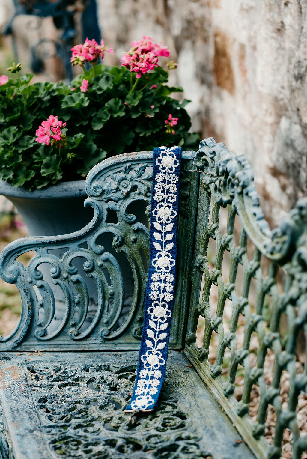 Tess Large Purse Strap displayed on a bench in an outdoor setting.