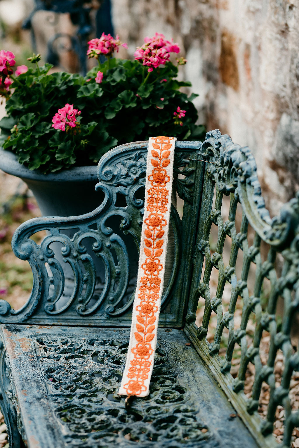 Rachel Large Purse Strap displayed on a bench in an outdoor setting.