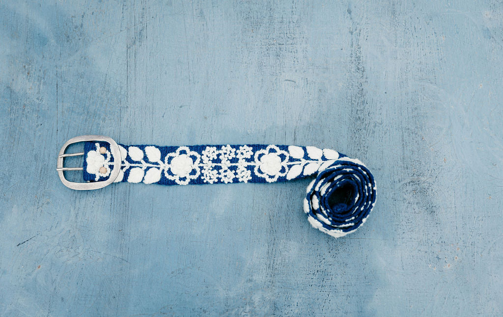 Tess Hand Embroidered Belt, a classic navy wool fabric with cream floral and leaves displayed on blue background.