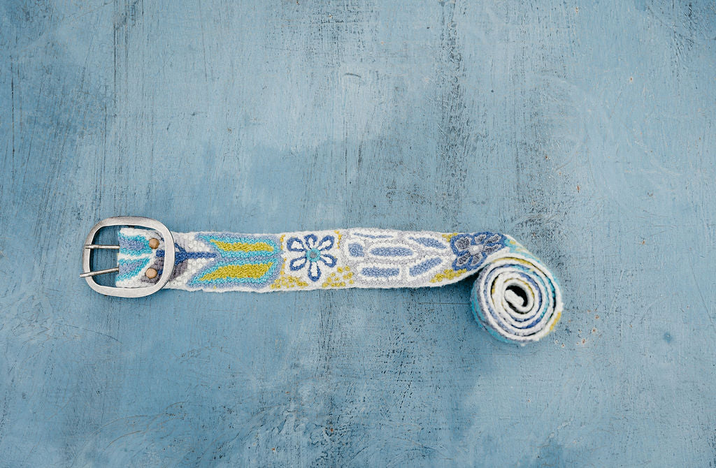 Yellow Embroidered Belt with Floral Design and Silver Buckle displayed on Blue Surface,