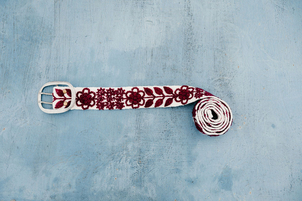 Wendi Hand Embroidered Belt with maroon floral and leaves embroidery displayed on blue background.