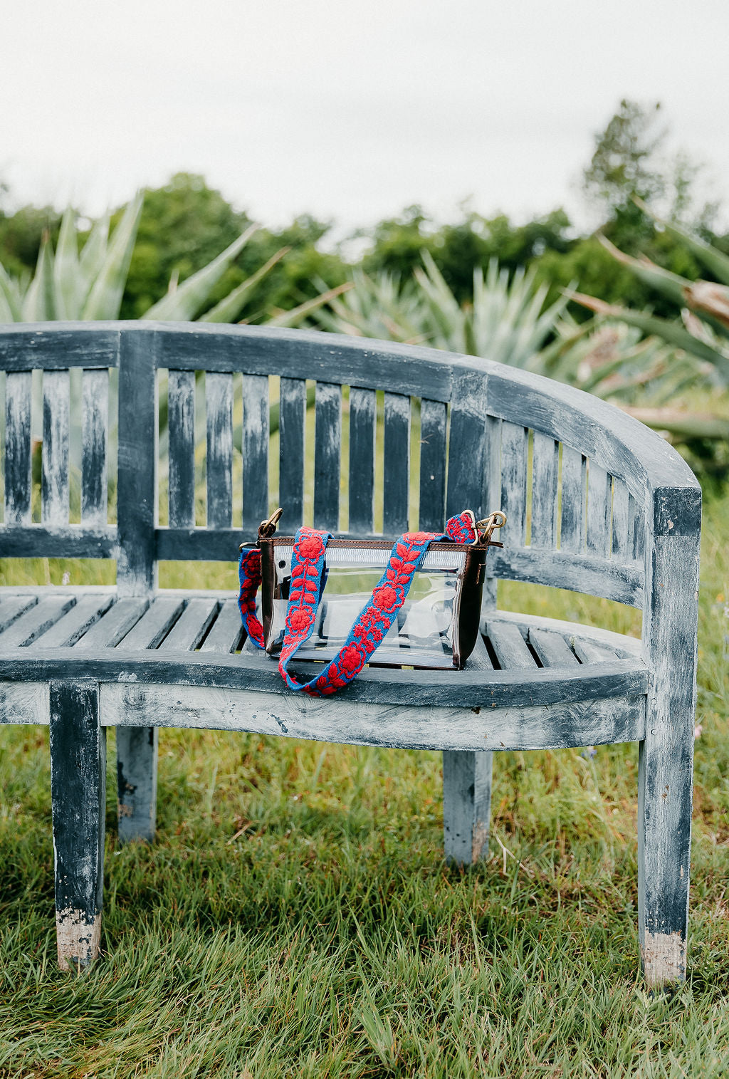 Taylor Adjustable Strap attached to a clear purse displayed on a bench
