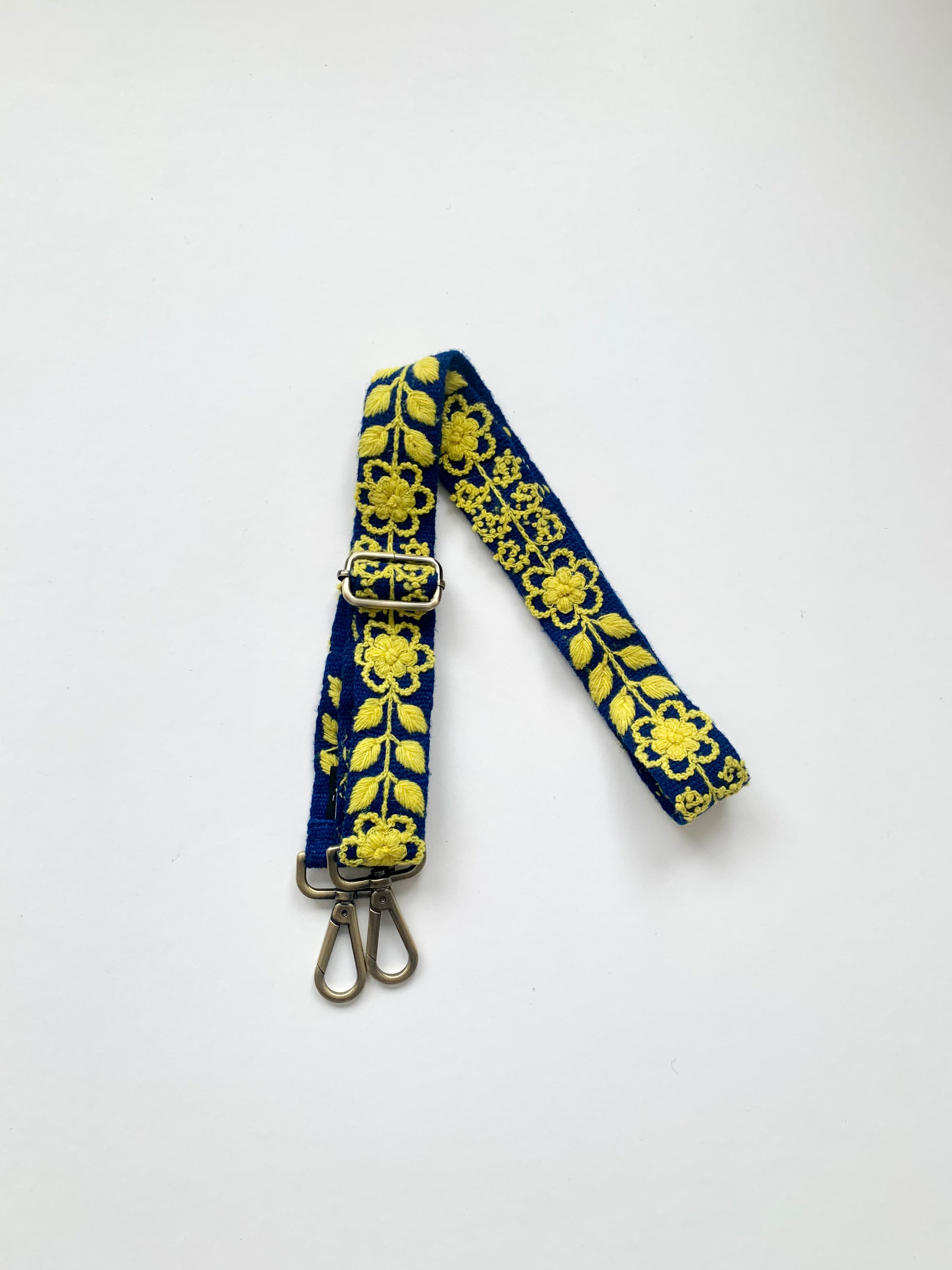 A blue and yellow strap with metal hooks and a buckle