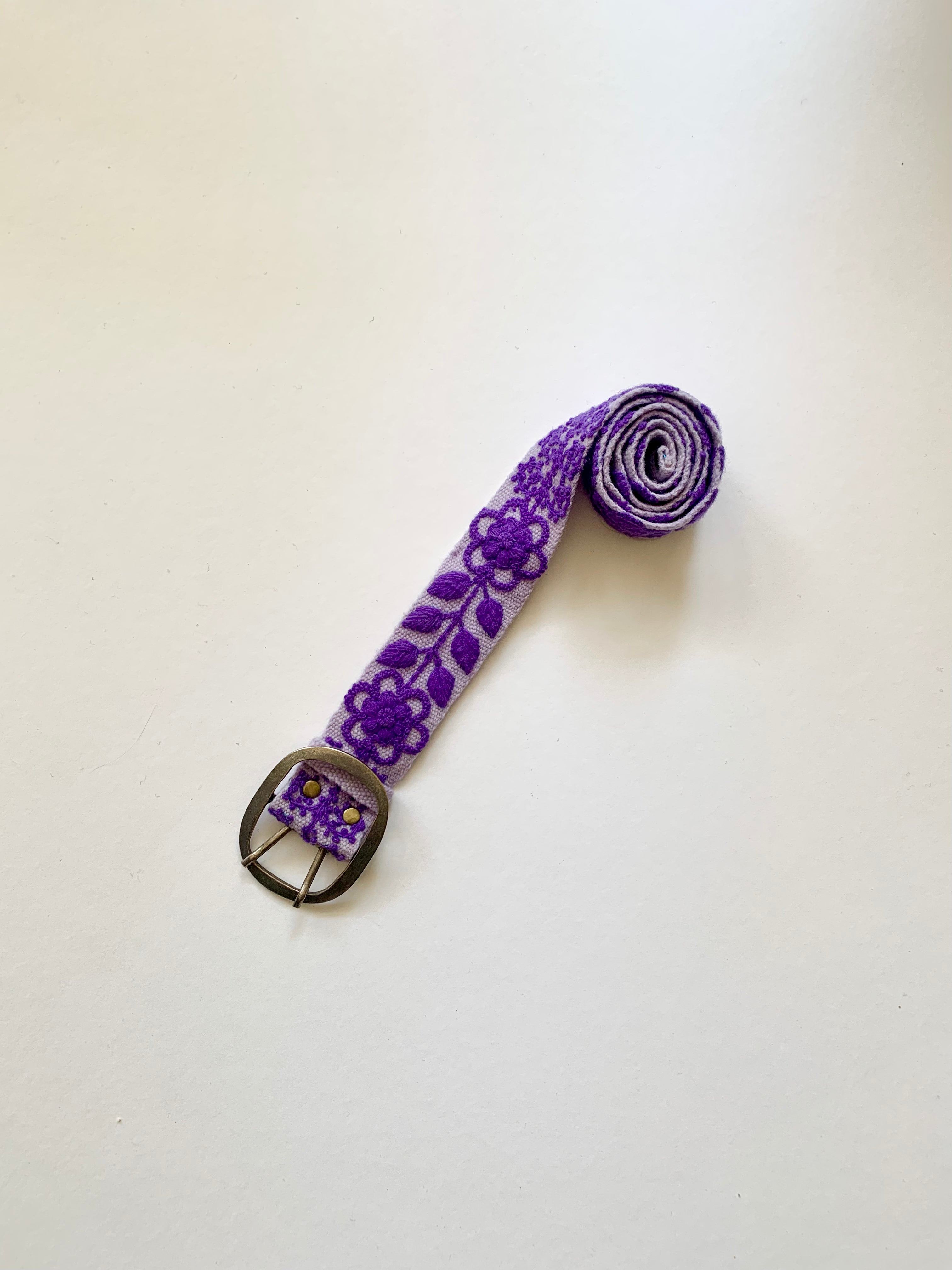 Eliza Embroidered Belt: A hand-loomed wool belt with a purple floral and leaf design