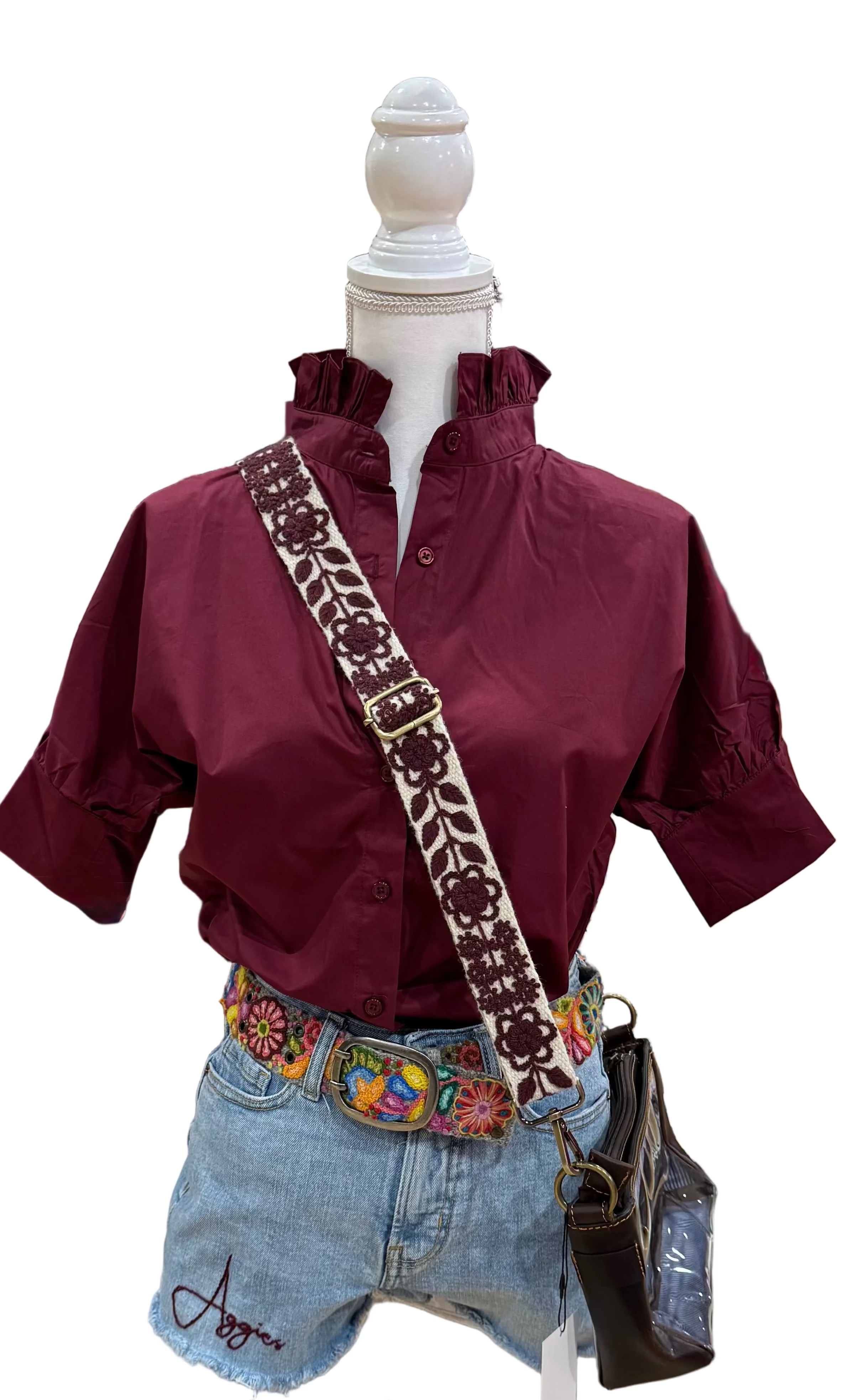 Heidi Houston Ruffle Shirt in Maroon on mannequin with embroidered cross-body strap, floral belt, and clear purse, styled with denim shorts.