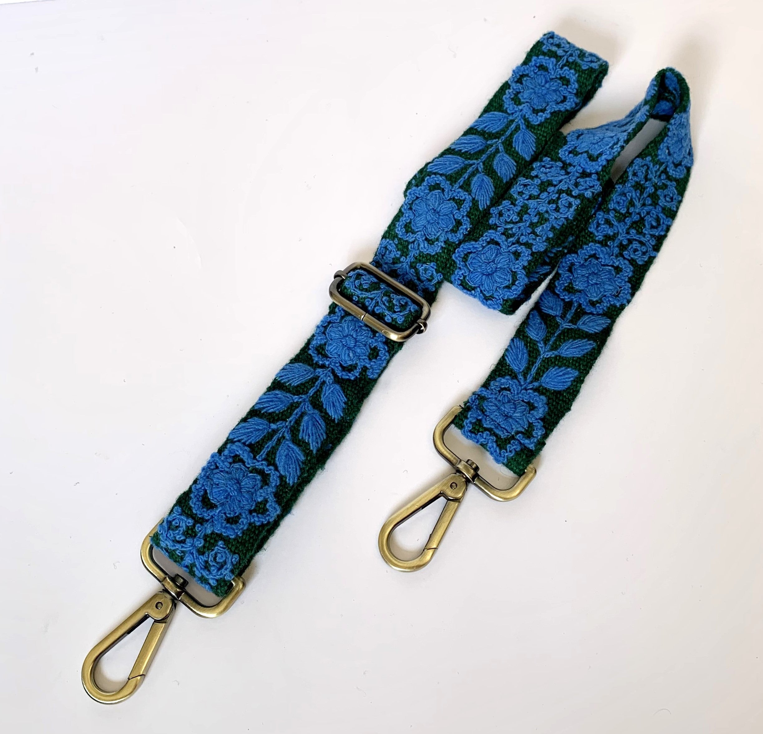 Green and blue adjustable purse strap with metal hooks and clasps