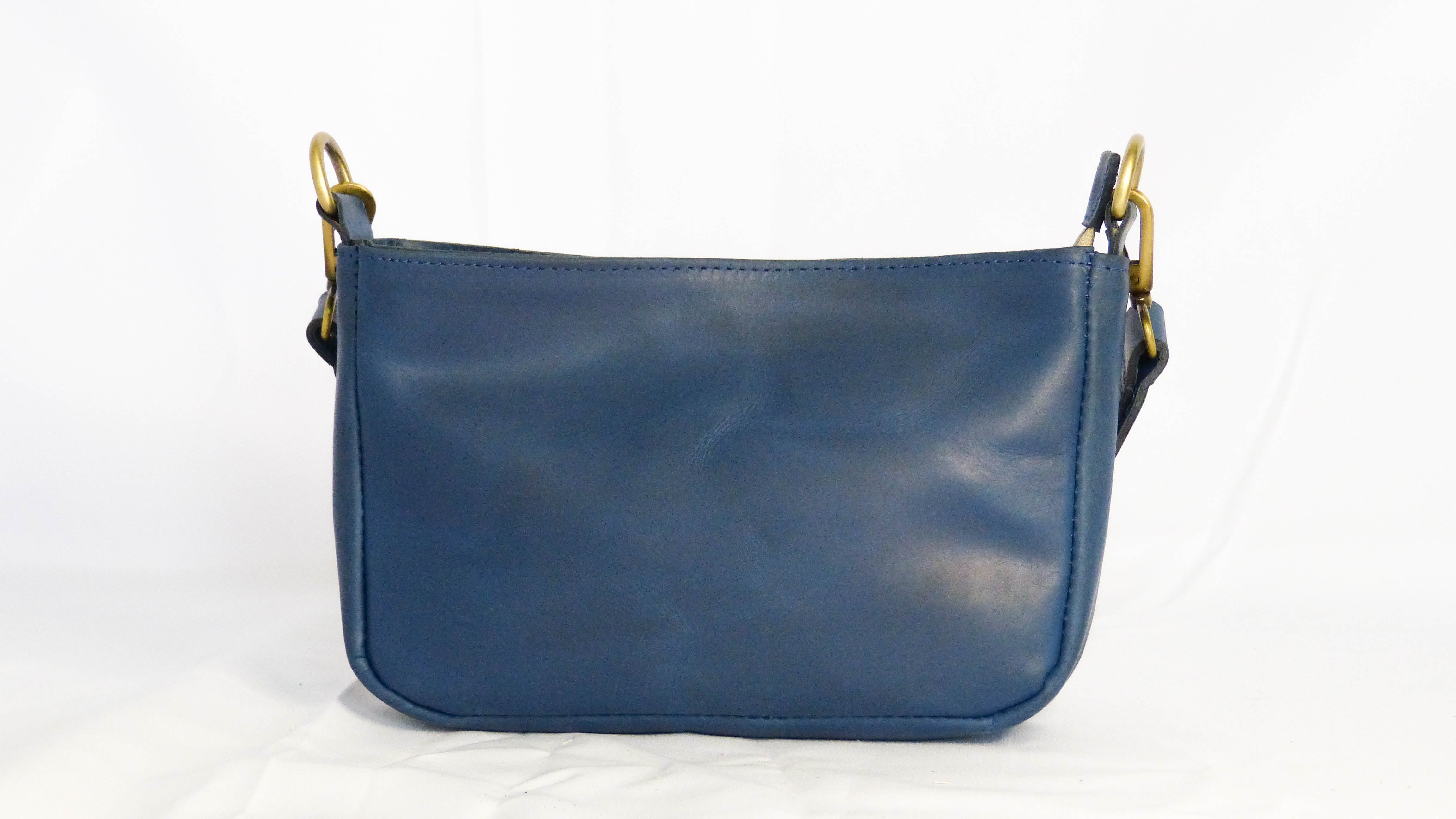 Handcrafted Jessica Leather Purse in Cornflower Blue with gold handles. Features zippered top, inside pocket, and removable shoulder strap. Ethically made by Ethiopian artisans.