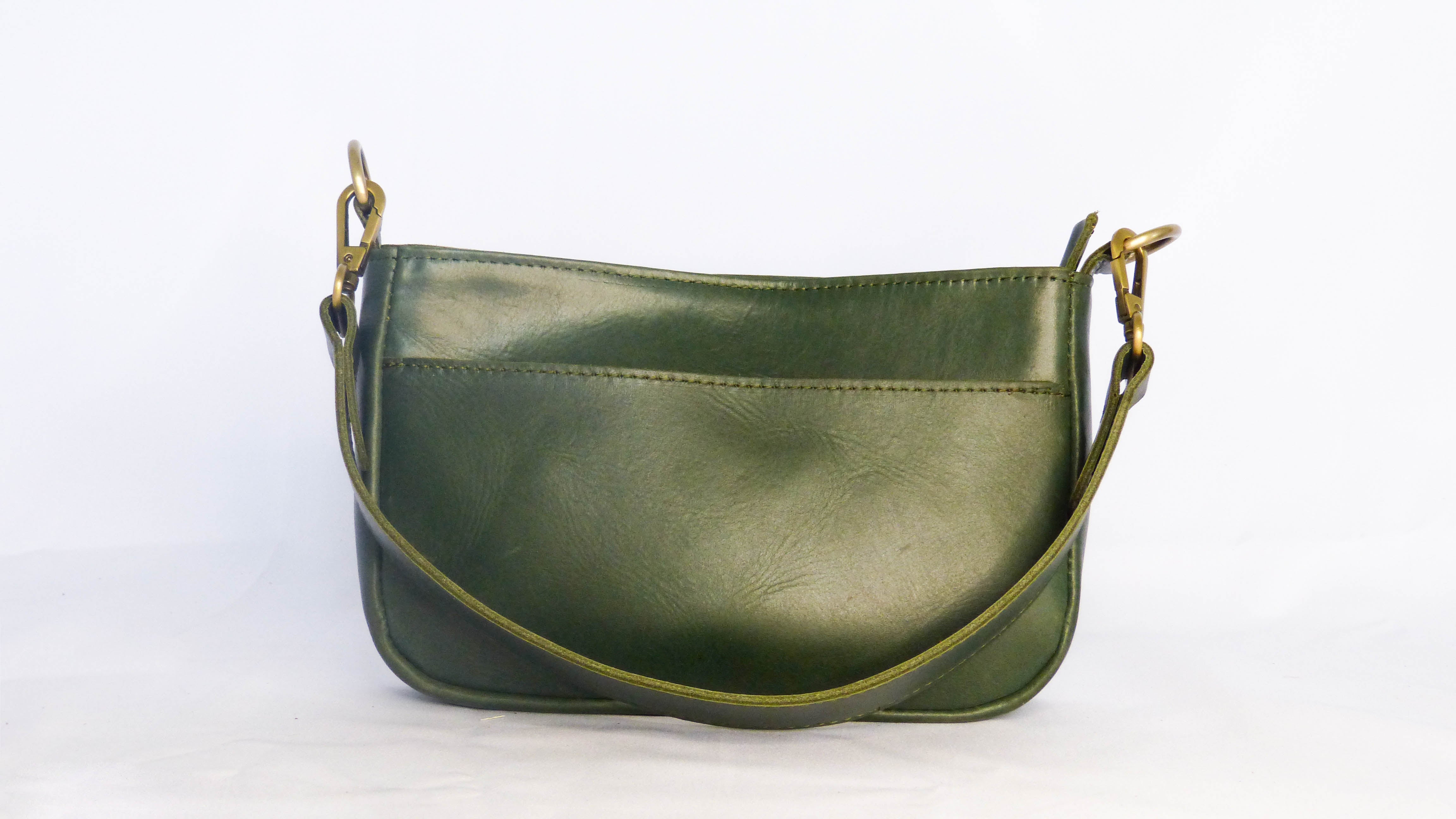 A green leather purse with a removable shoulder strap. Features a zippered top, inside zipper pocket, and outside phone pocket. Handmade by Ethiopian artisans. Measures 9 x 5.5 x 2.25.