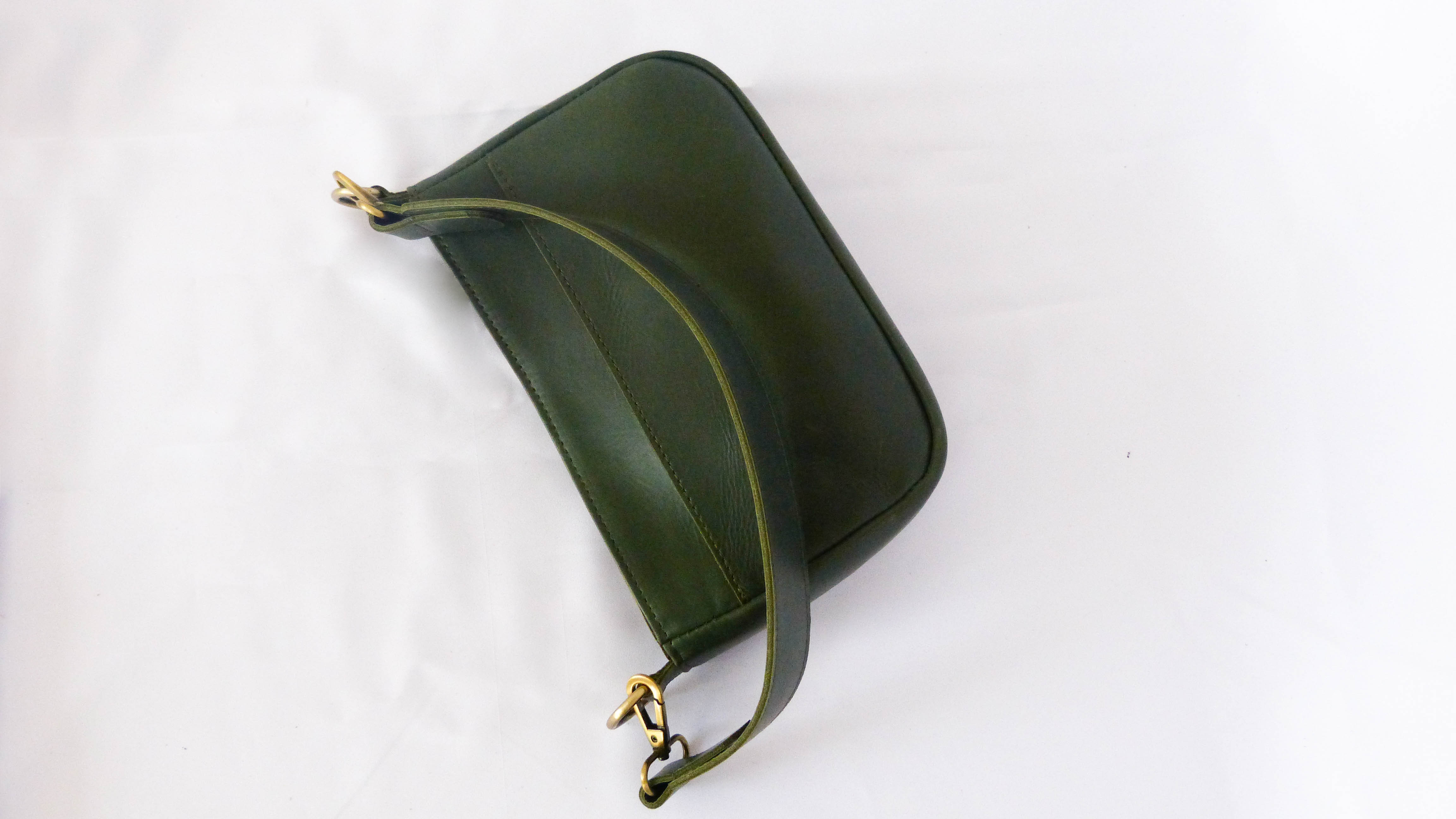 Handcrafted Jessica Leather Purse in Hunter Green, featuring removable shoulder strap, zippered top, inside pocket, and phone-sized outside pocket. Ethically made by Ethiopian artisans.