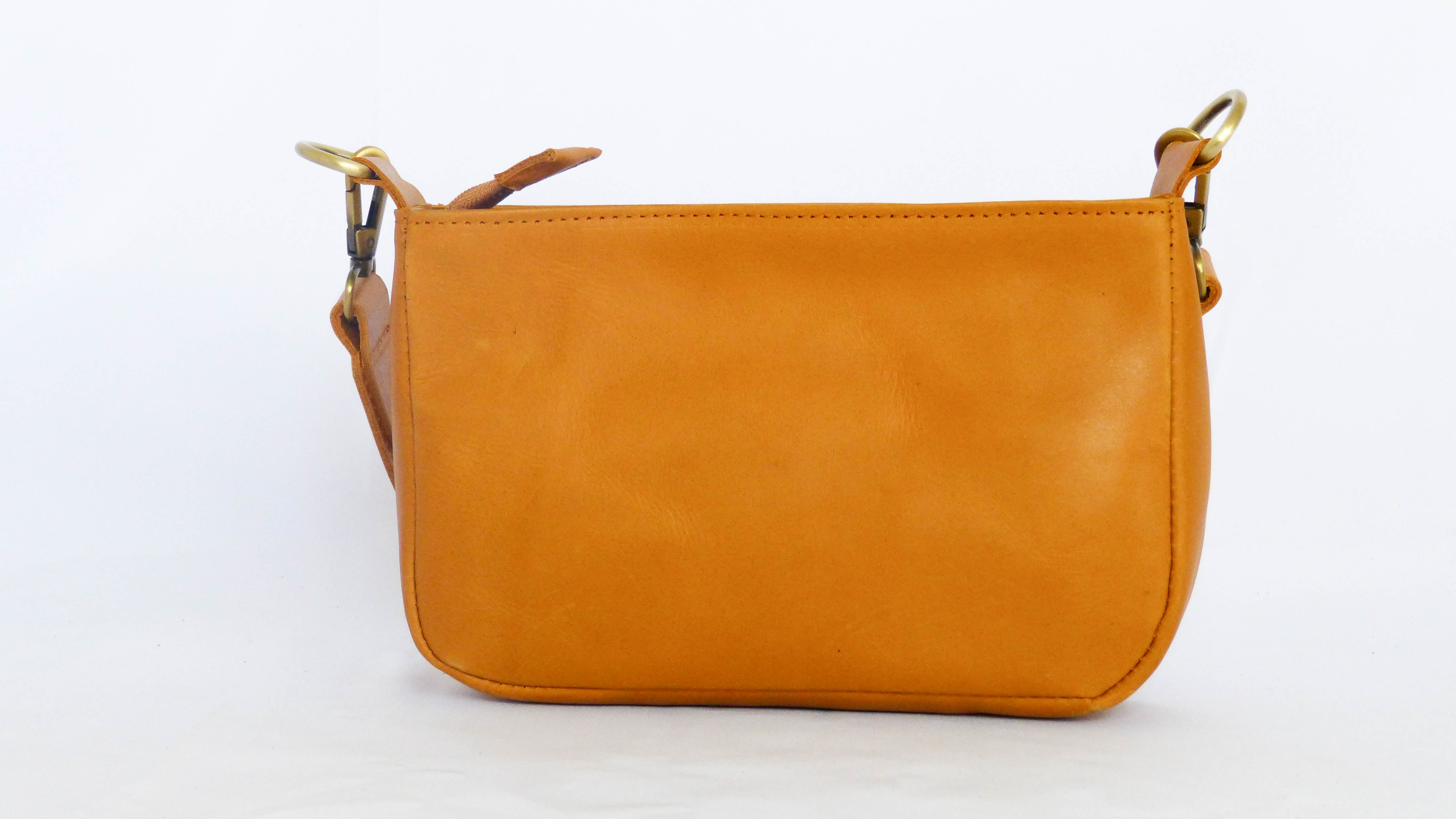 Close-up of the Jessica Leather Purse in Honey, featuring a removable shoulder strap, zippered top, and phone pocket. Handmade by Ethiopian artisans with soft leather. Dimensions: 9 x 5.5 x 2.25.