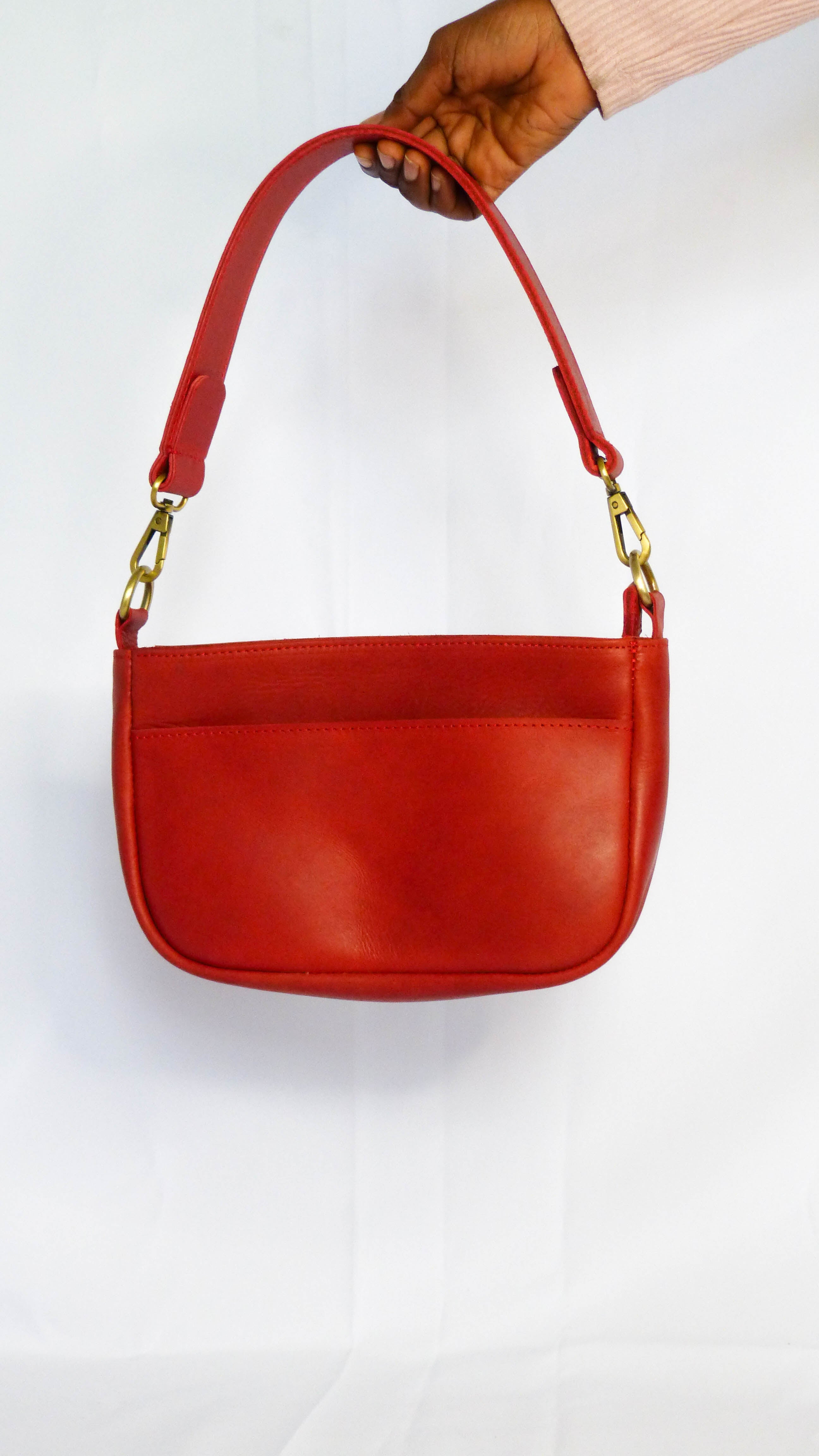 Handcrafted Jessica Leather Purse in Cherry with gold handles and removable shoulder strap. Features zippered top, inside zipper pocket, and outside phone pocket. Ethically made by Ethiopian artisans.