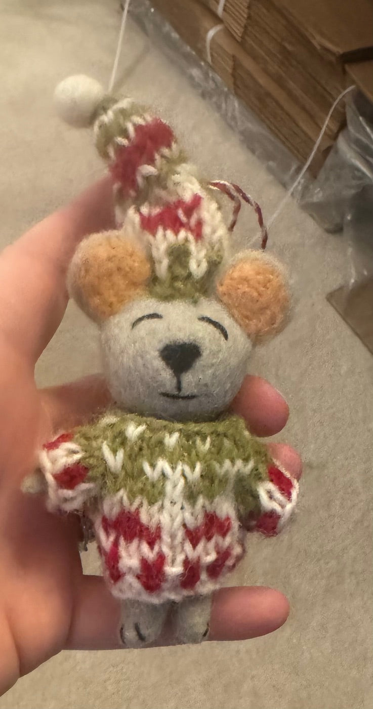 Hand holding a small knitted Mouse Ornament, showcasing its intricate design and craftsmanship, reflecting Madeline Parks ™'s commitment to artisan-made products.