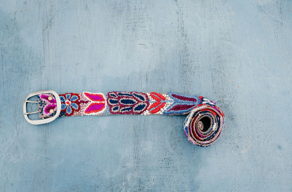 Purple Embroidered Belt with hand loomed wool fabric and floral embroidery displayed on blue background.