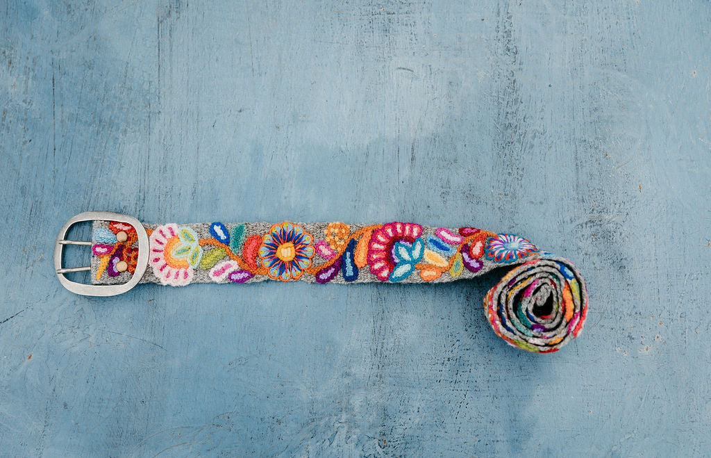 Bright Embroidered Belt with Colorful Florals displayed on blue background.