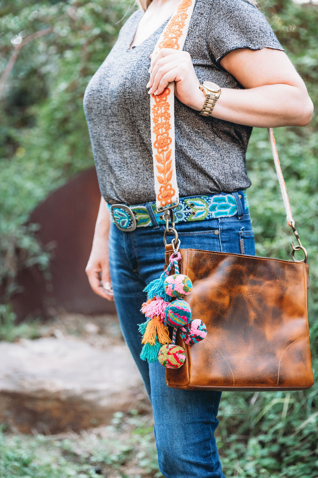 A person holding the Rachel Large Purse Strap attached to a brown leather bag.